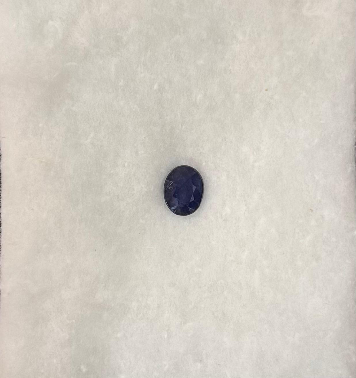 Single dark blue gemstone on a textured white background