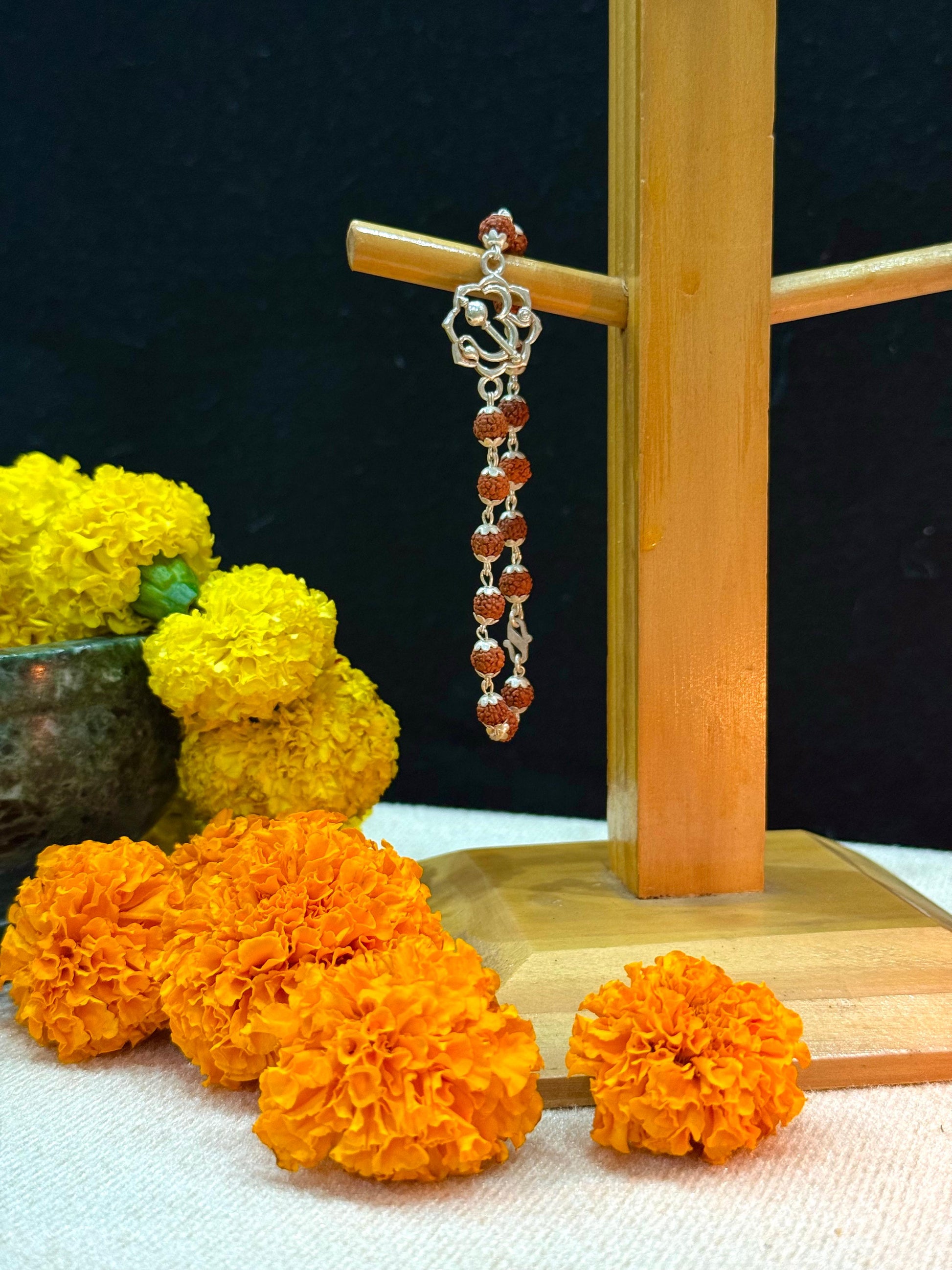 Earring with marigold flowers on a dark background