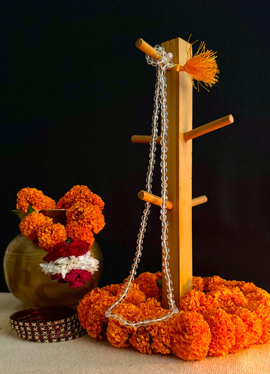 Decorative setup with a wooden frame, chain, and marigold flowers on a dark background
