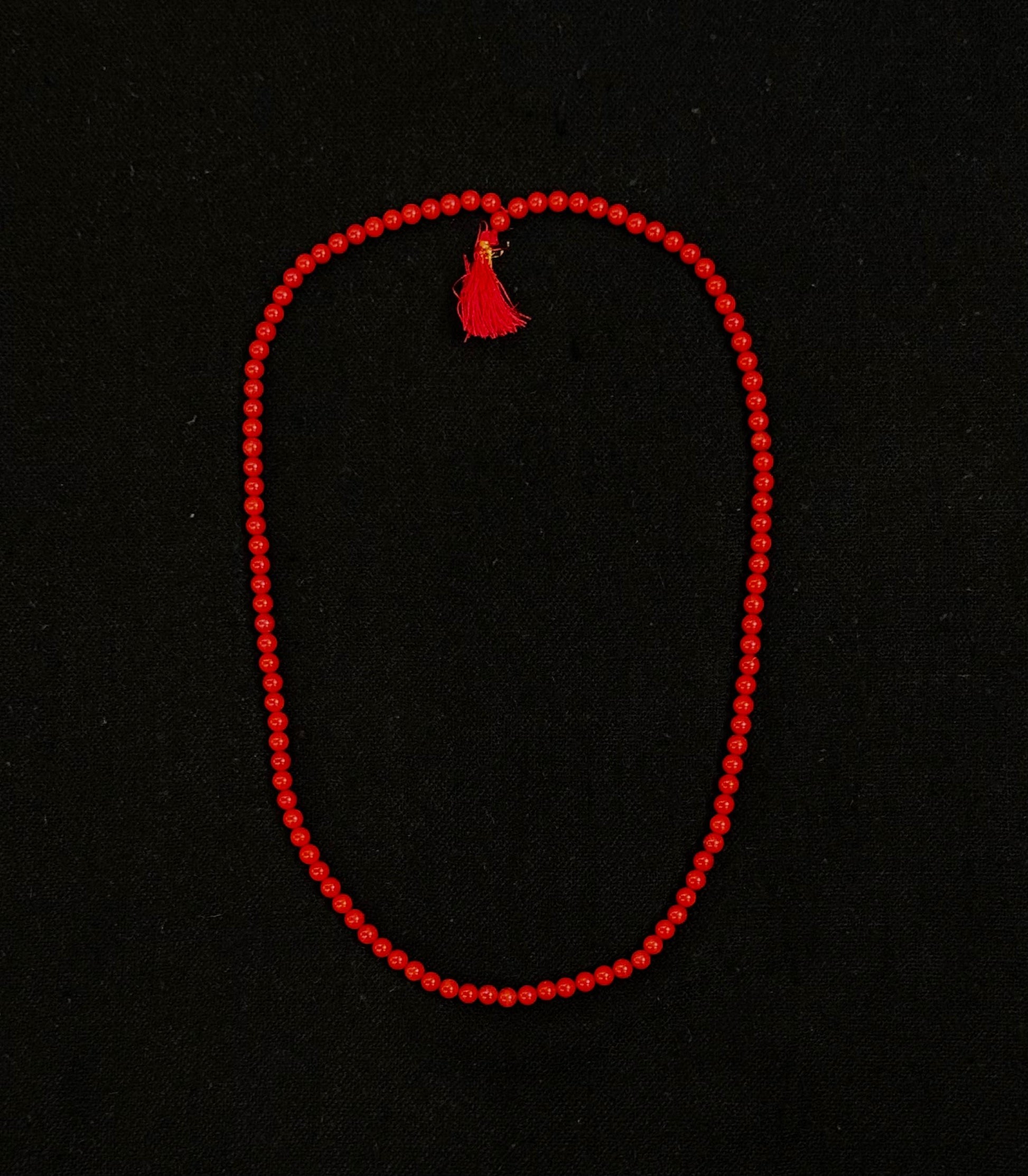 Red string with a tassel on a black background