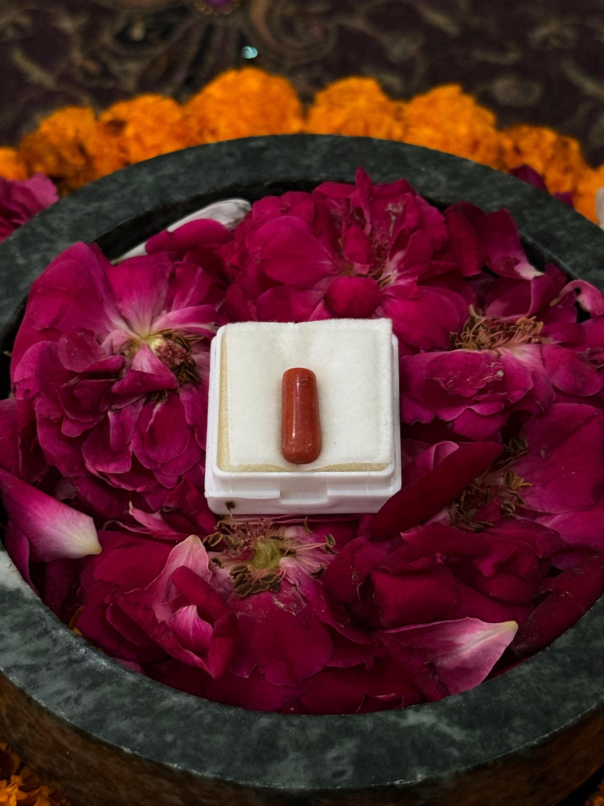 Jewelry box with a red gemstone on pink flowers