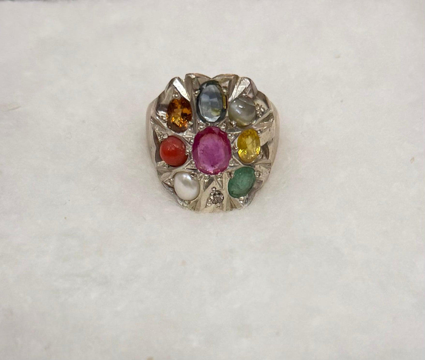 Ring with multicolored gemstones on a white background